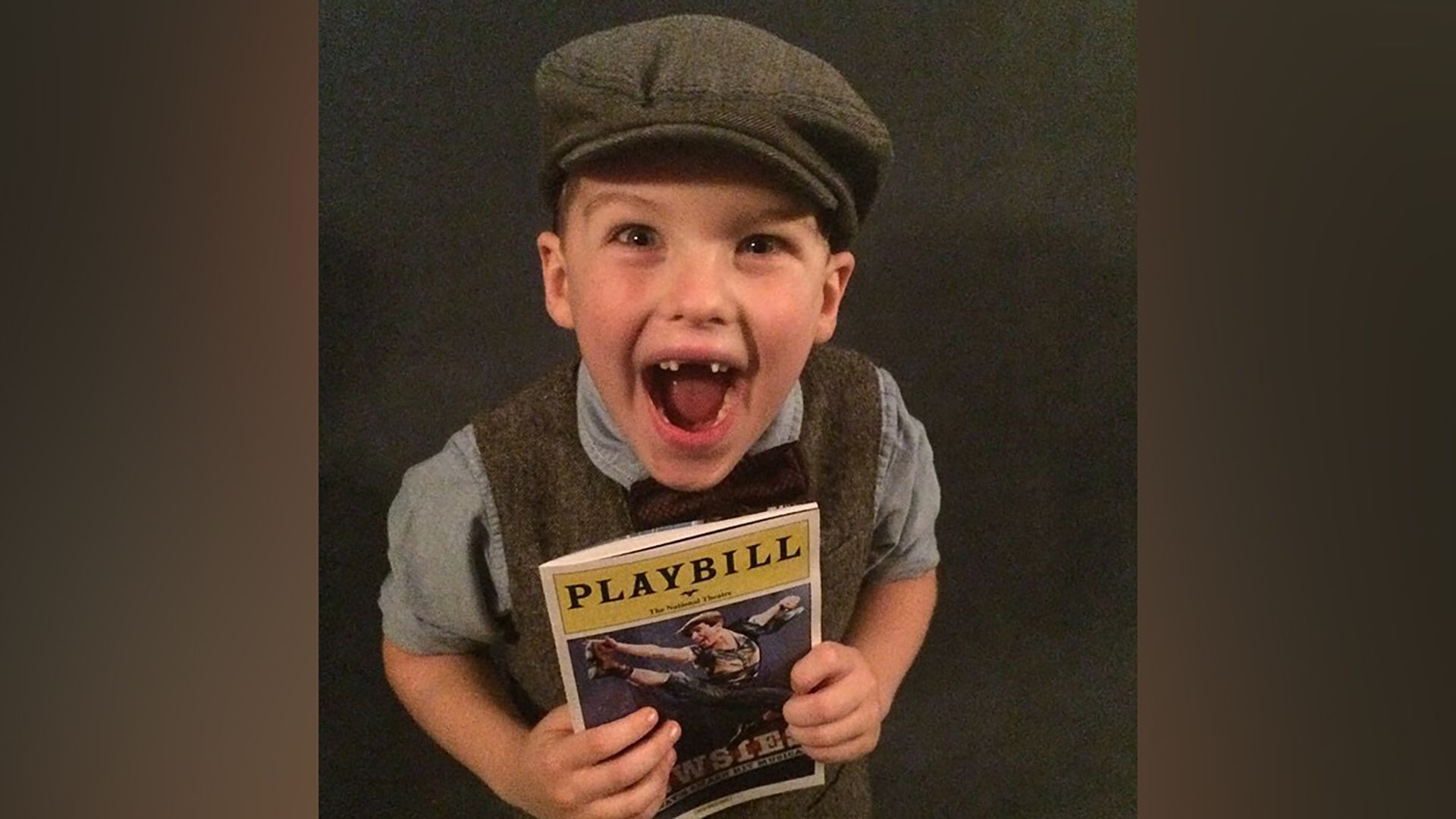 Young Iain Armitage with a theater program