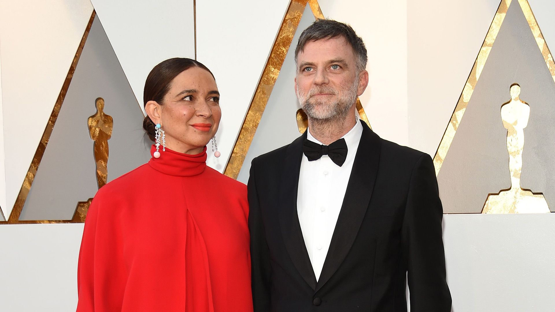 Paul Thomas Anderson in a tuxedo and Maya Rudolph in a red dress at the Oscars ceremony