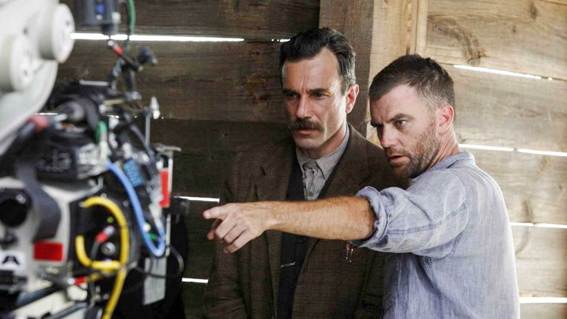 Paul Thomas Anderson pointing Daniel Day-Lewis toward the camera with his hand