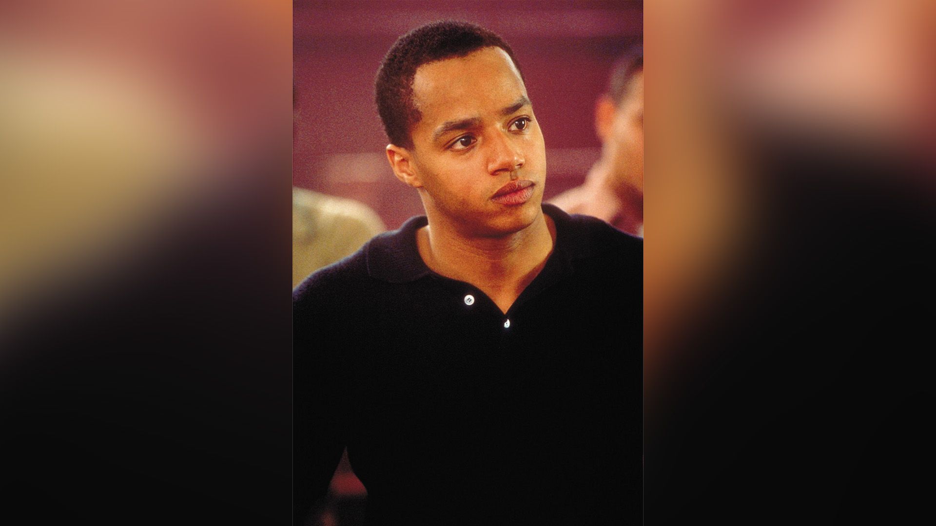Young Donald Faison in a black polo