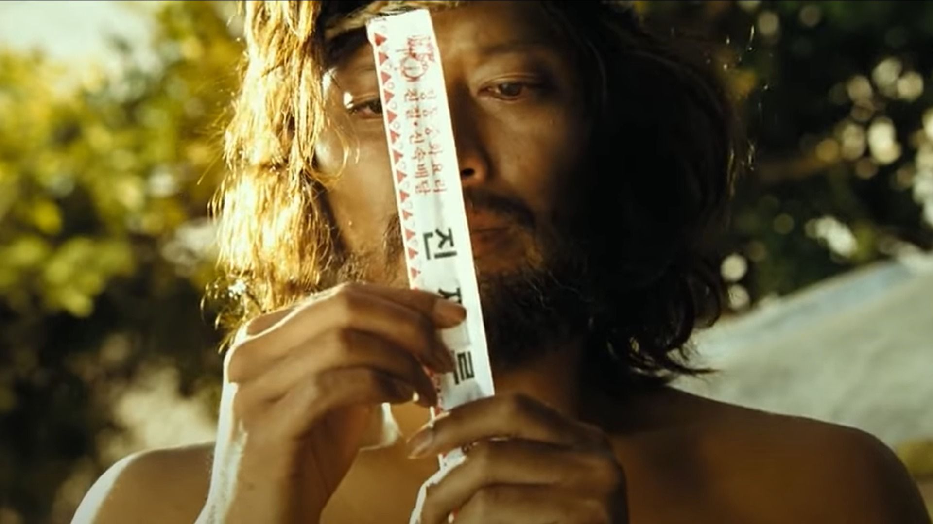 Long-haired man holding a package of chopsticks