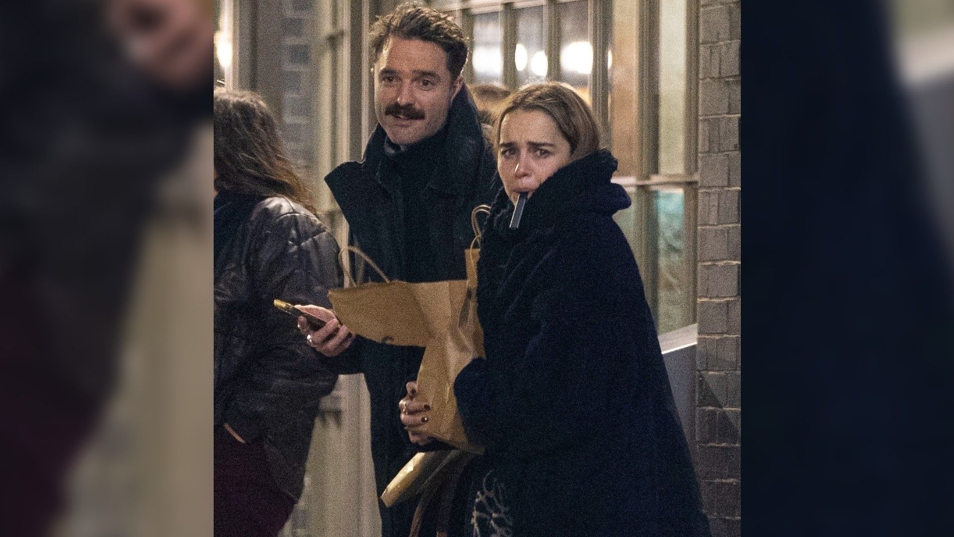 Emilia Clarke and Bassi Fox walking down the street in winter clothes
