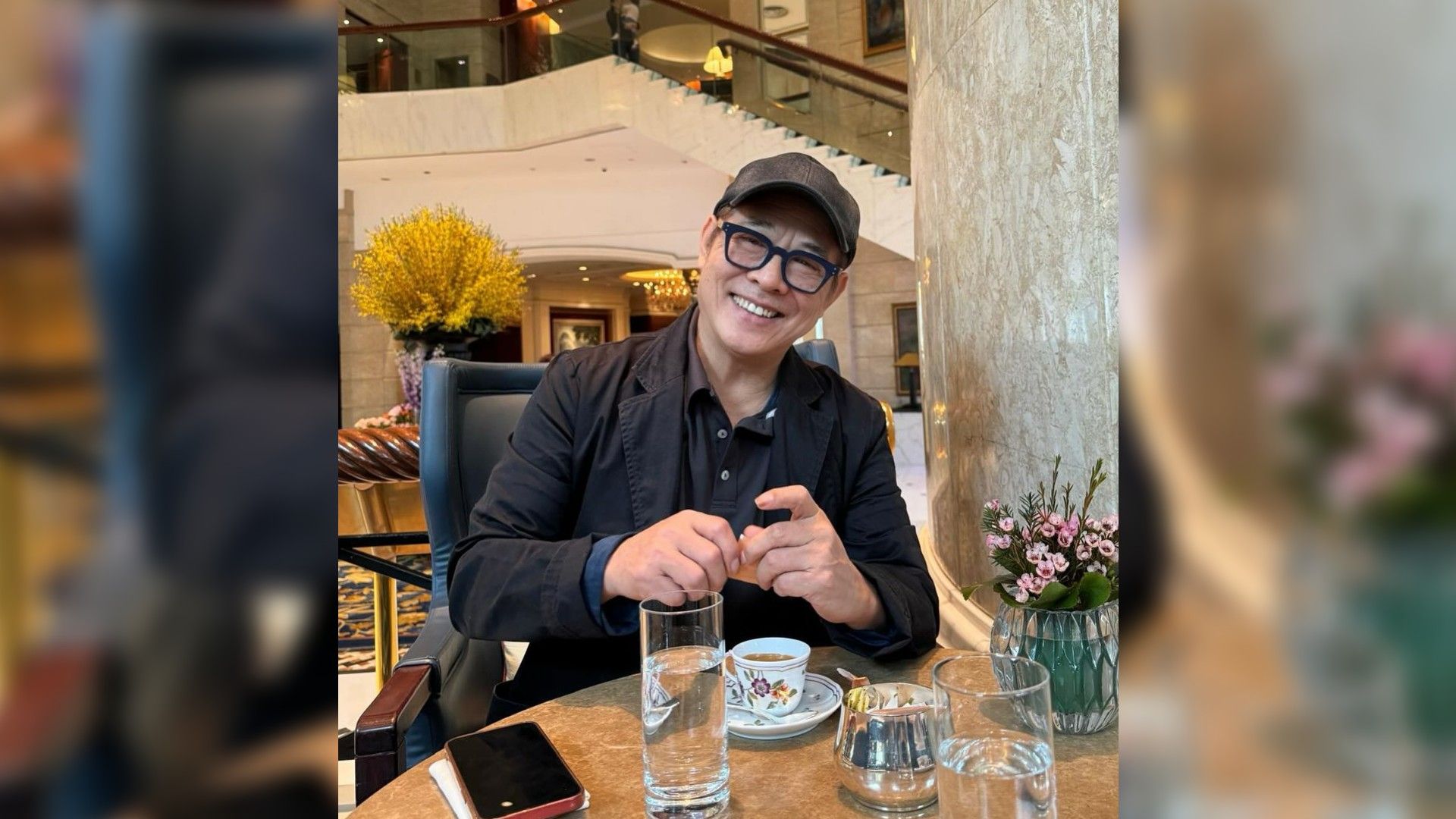 Jet Li wearing a cap and sunglasses dining at a restaurant