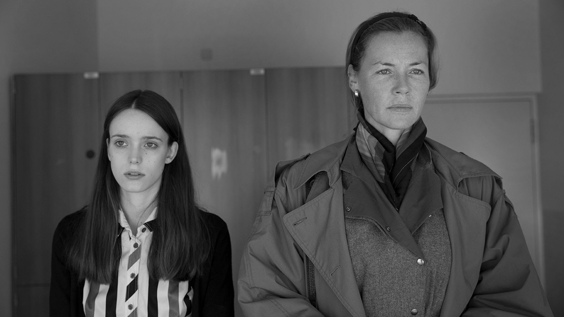 Connie Nielsen with a serious expression standing next to a young girl