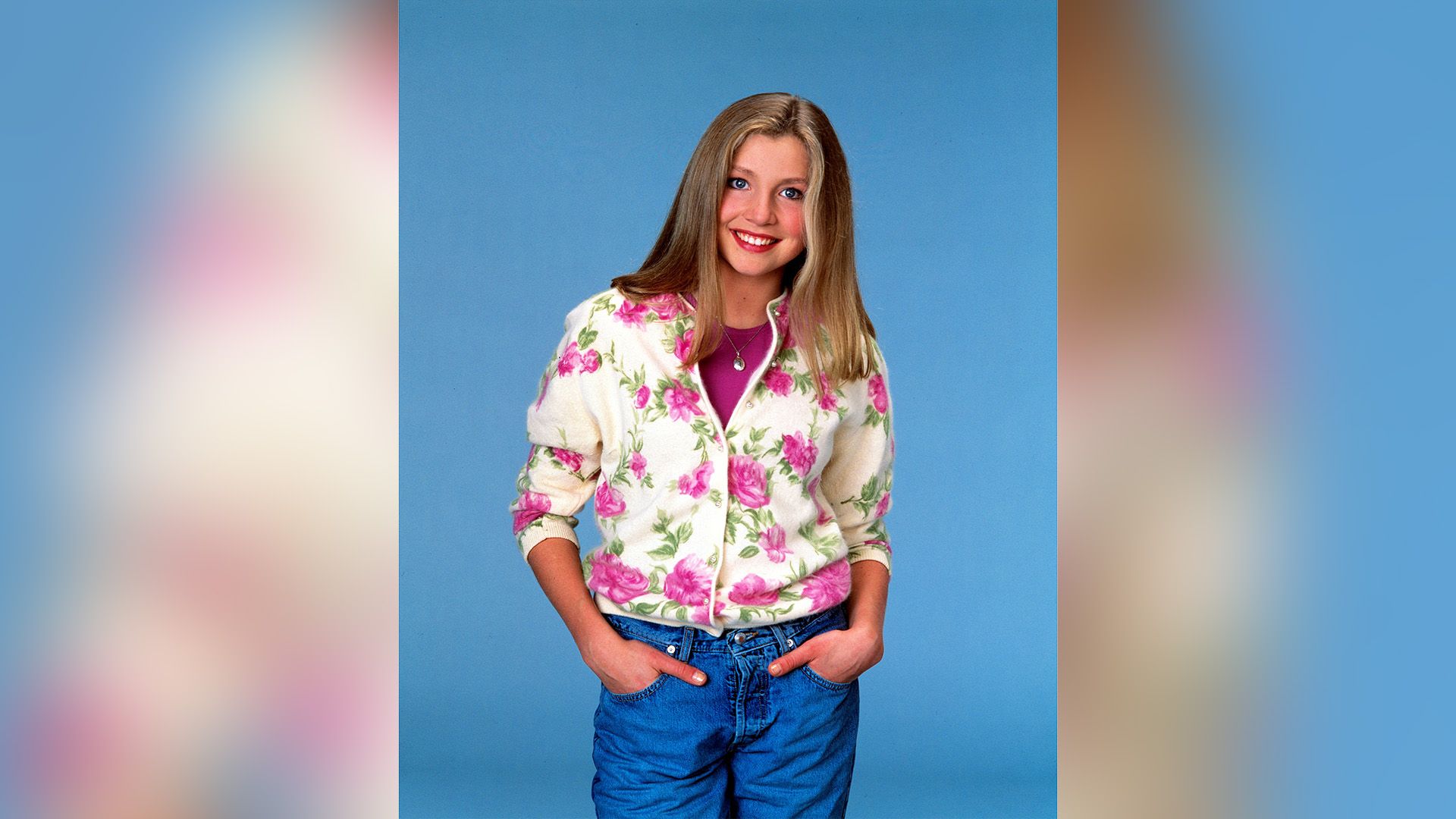 Sarah Chalke in jeans and a white sweater with large pink flowers