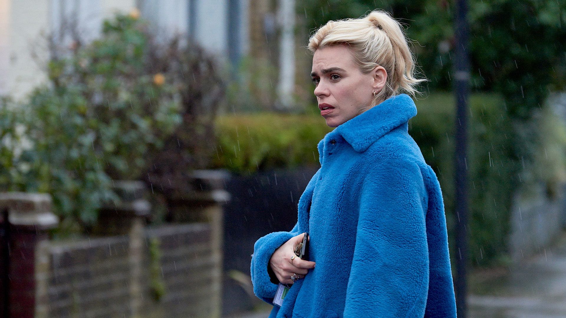 Billie Piper in a blue plush coat standing on the street