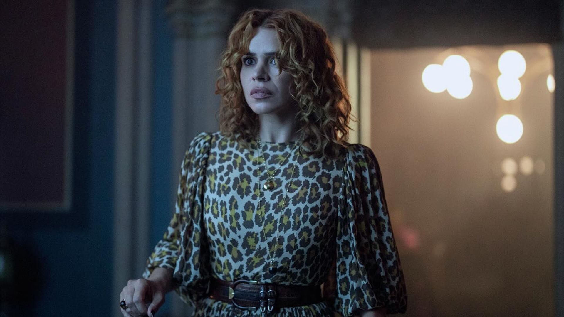 Billie Piper with red curls and in a leopard print dress