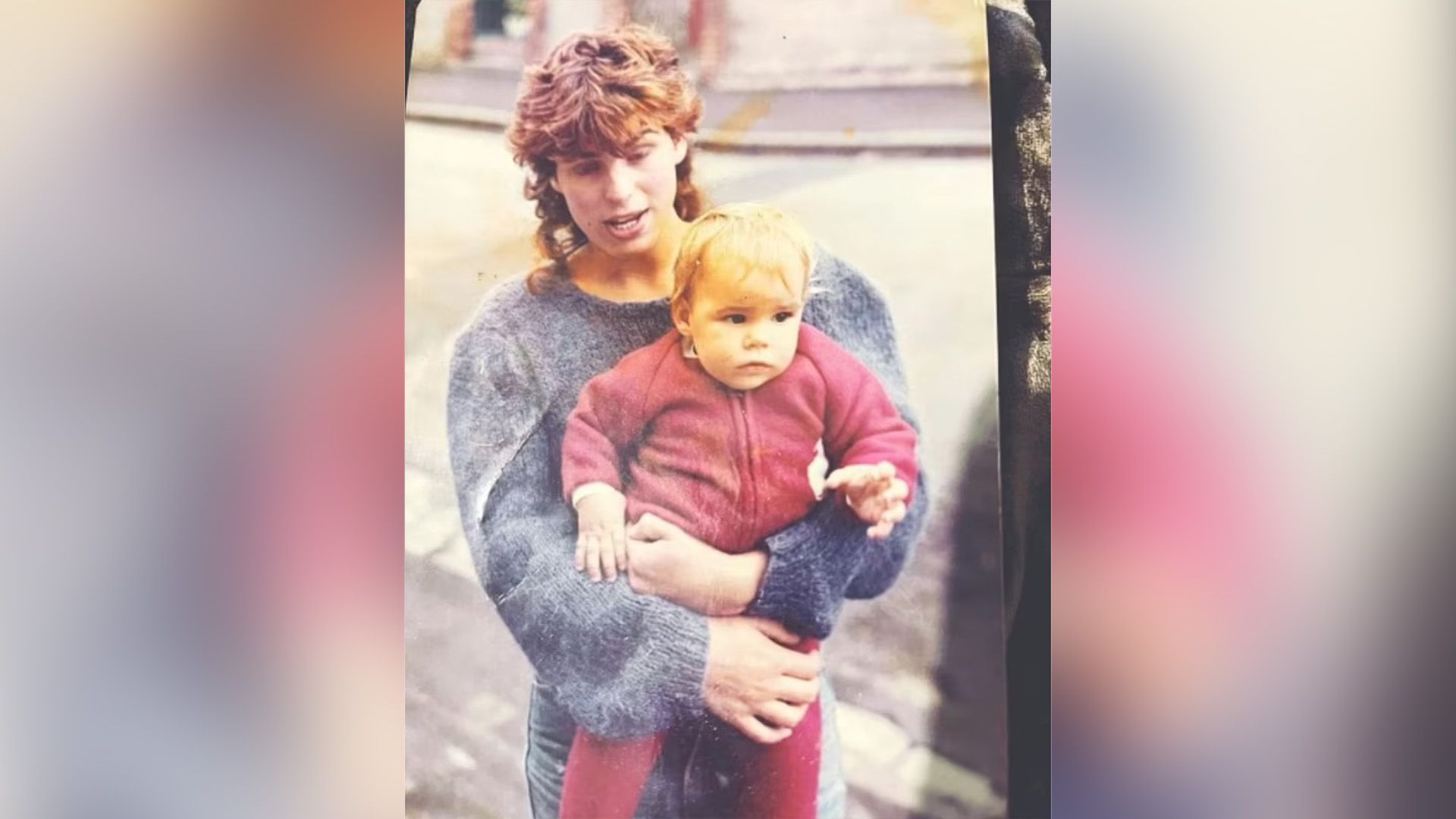 Little Billie Piper in a red romper in her mum's arms