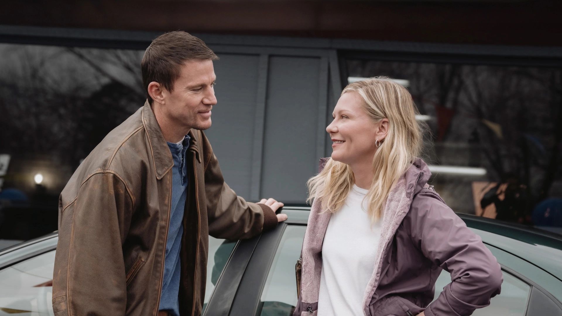 Kirsten Dunst and Channing Tatum stand facing each other and smiling