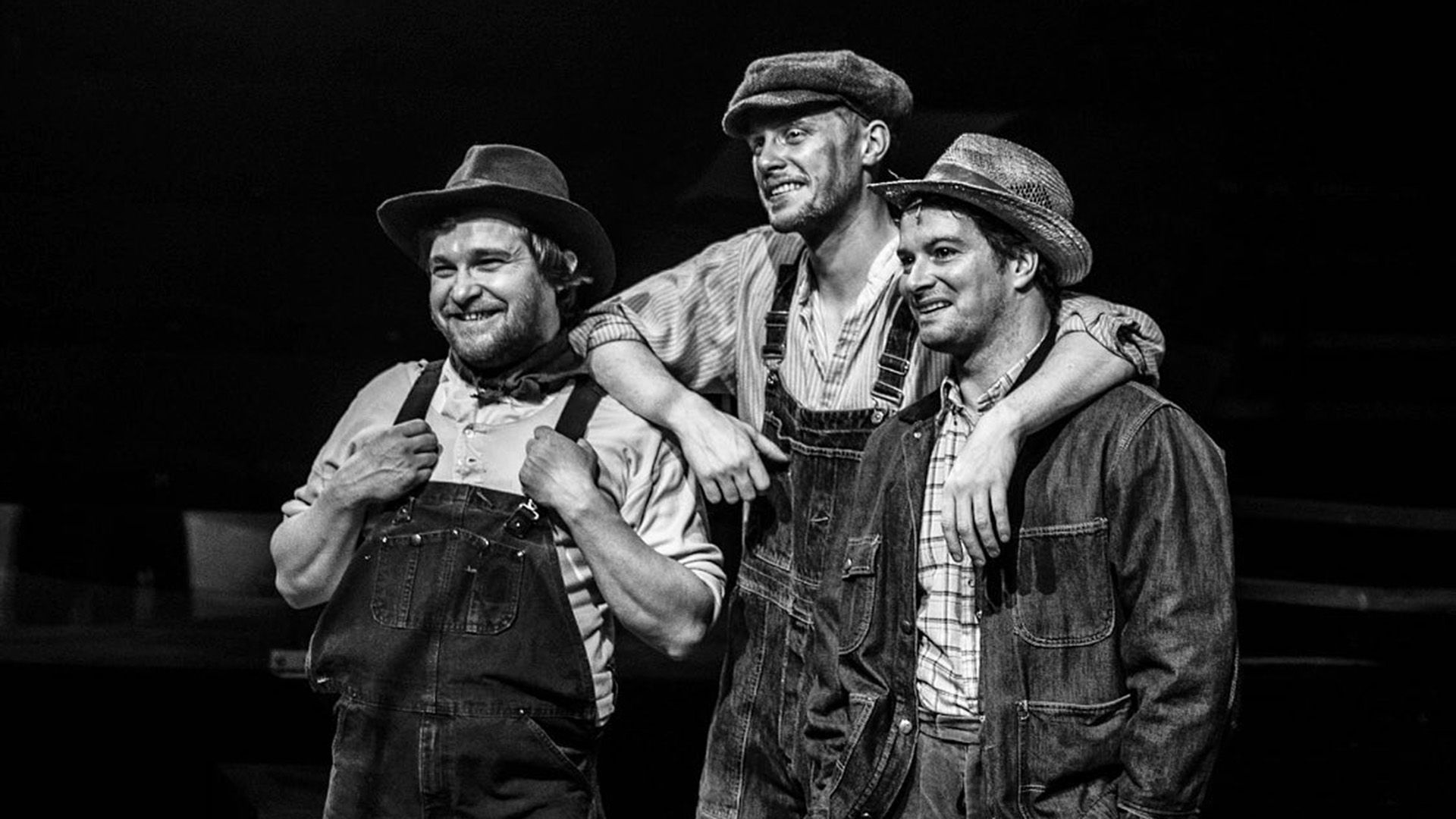 Max Parker and two men in denim overalls and farmer hats