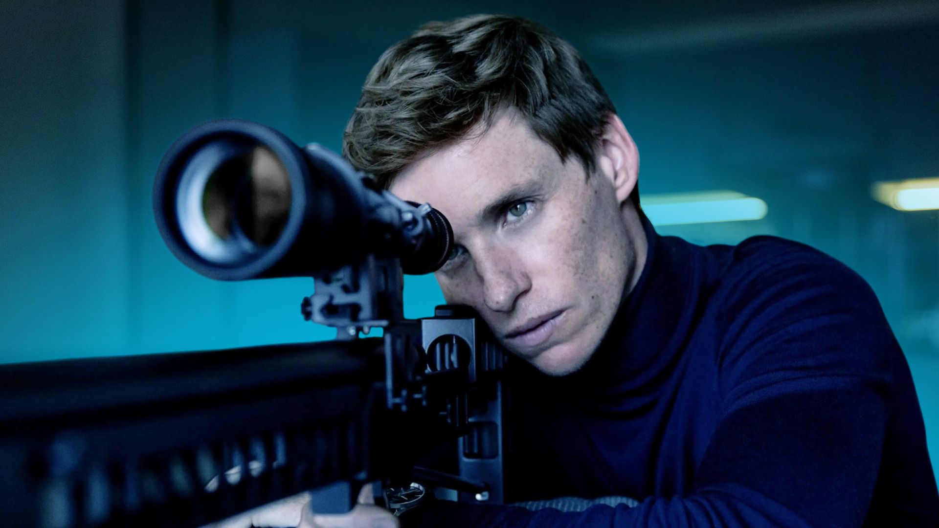 Eddie Redmayne looking through a sniper rifle scope
