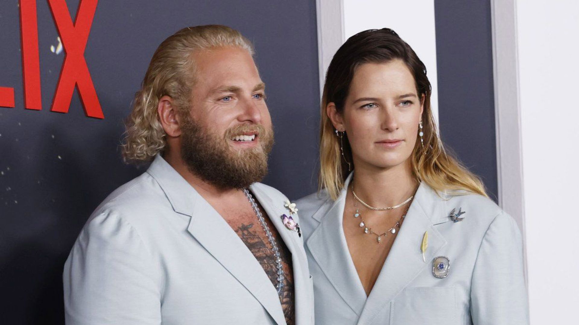 Jonah Hill and Sarah Brady pose in front of a Netflix backdrop