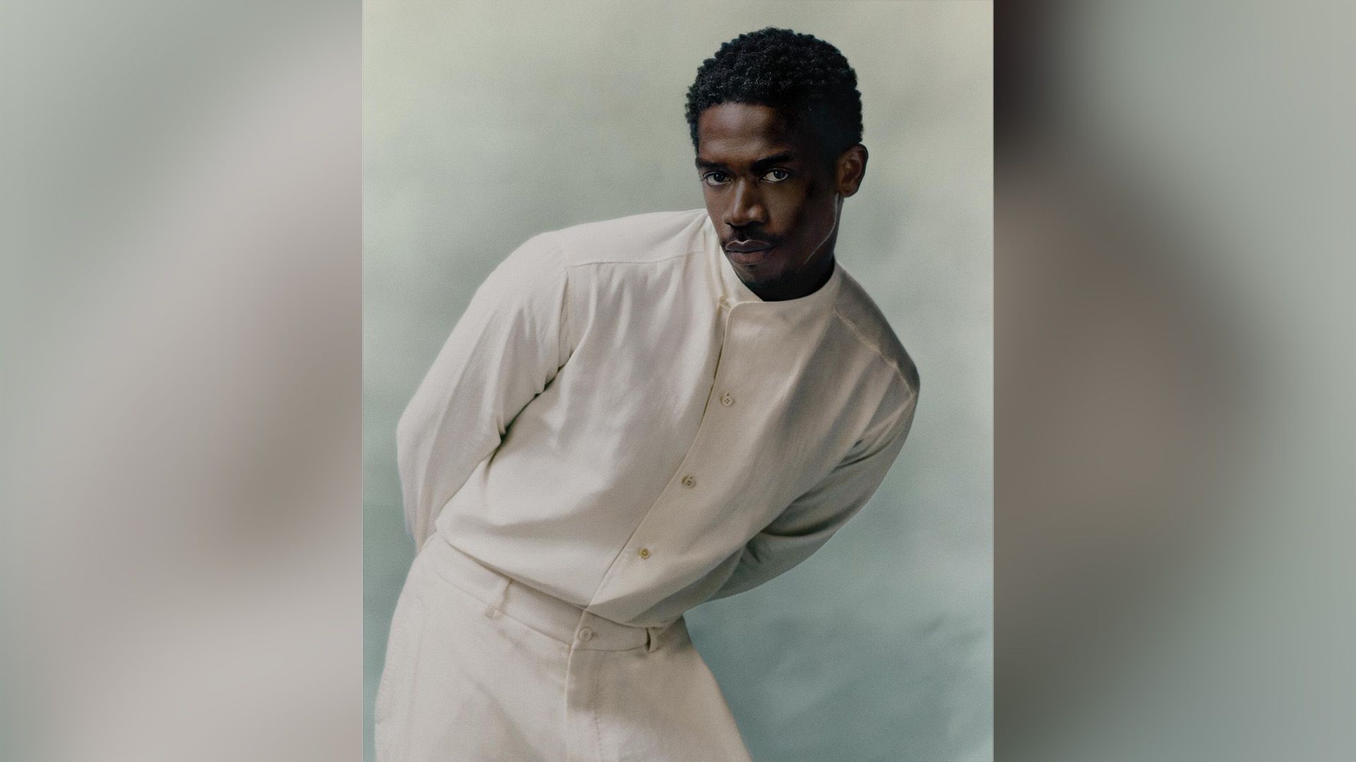 Actor Damson Idris in a white shirt and white pants