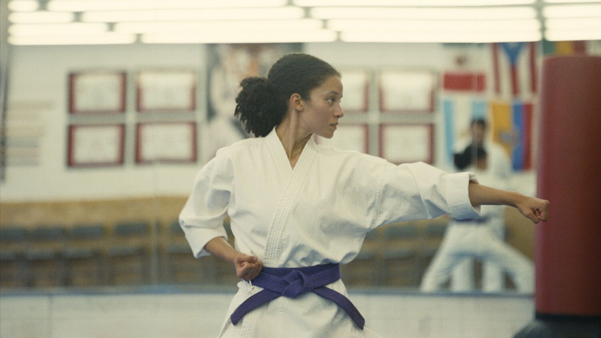 Chase Infinity in a white kimono with a purple belt standing in a fighting stance