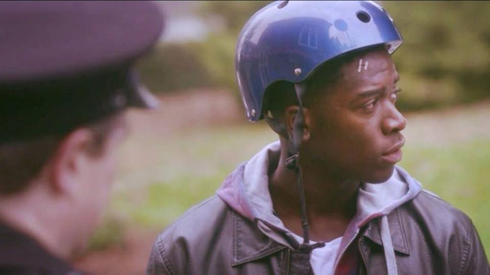 Damson Idris wearing a bicycle helmet, in profile