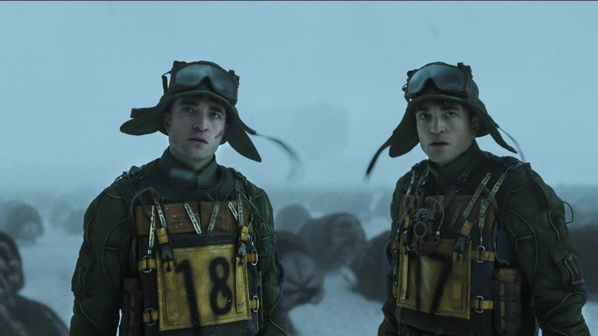 Two Robert Pattinsons in matching outfits with numbers 17 and 18, film still