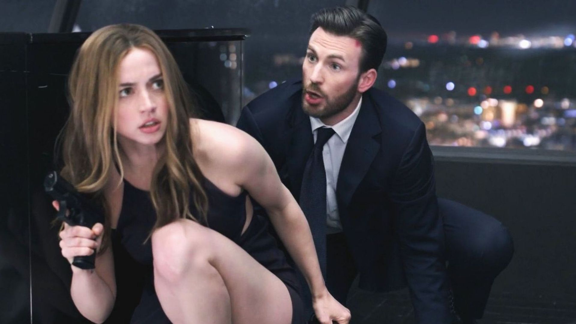 Ana de Armas and Chris Evans both look tense and focused as if they're gearing up for action