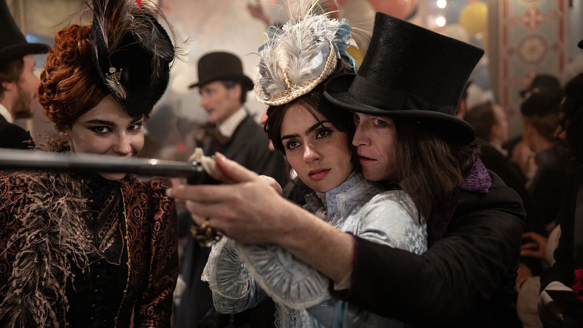 Zoe Bleu in Victorian attire aiming a rifle with help from Caleb Landry Jones in a top hat