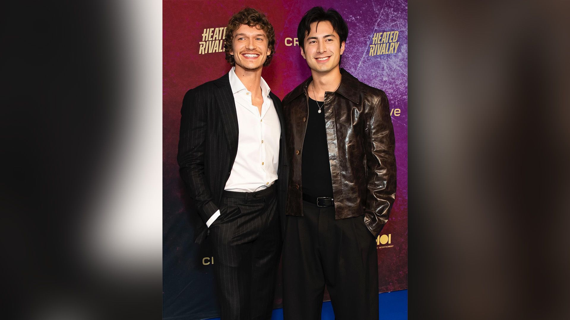 Connor Storrie in a striped suit and Hudson Williams in a leather jacket