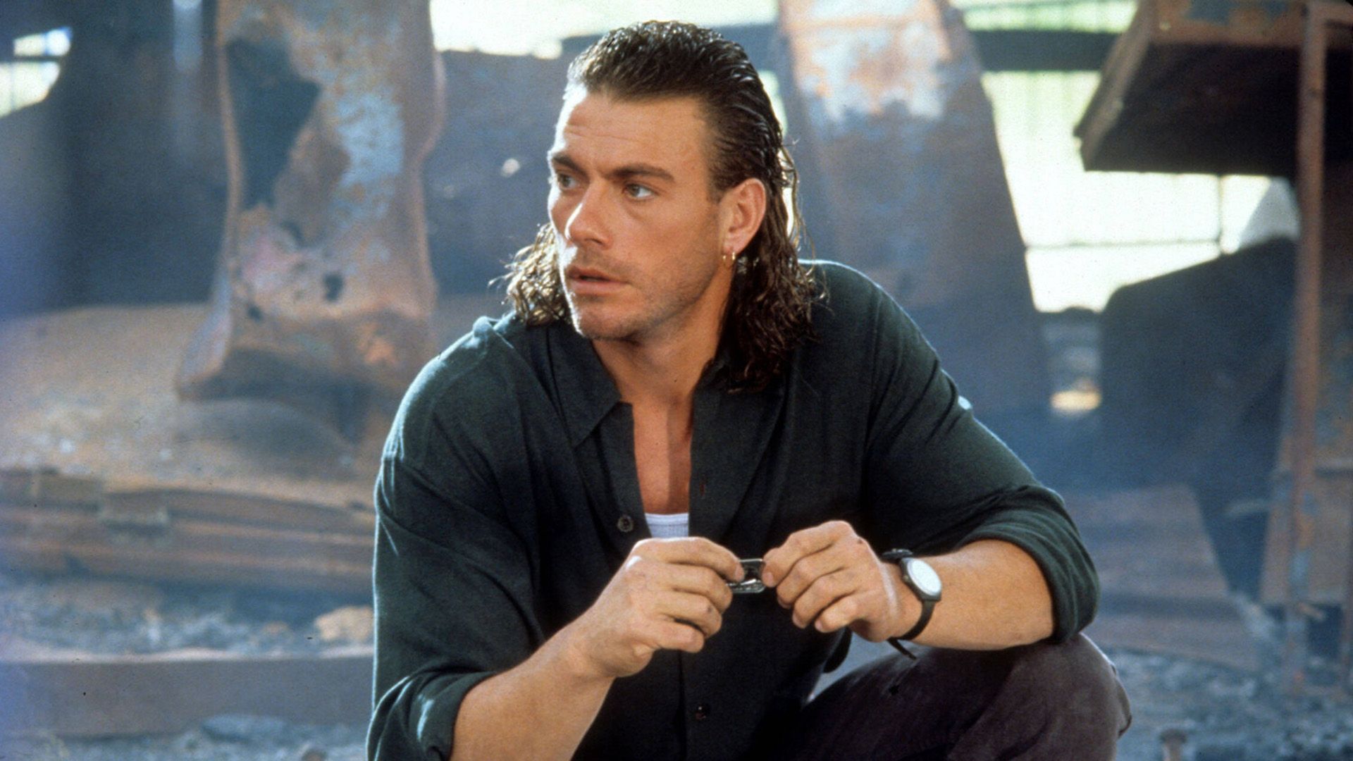 Young Jean-Claude Van Damme with long hair looking to the side