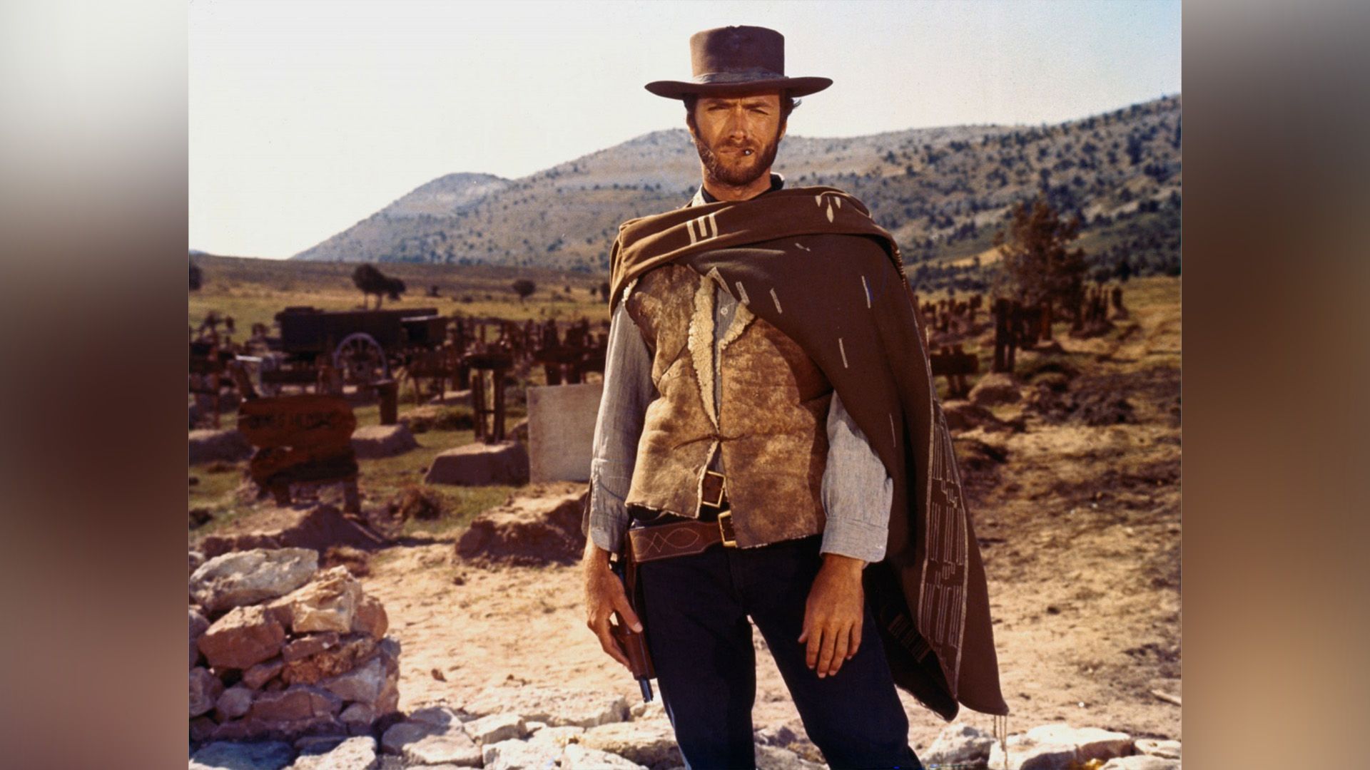 The ambiance of the Wild West, a bearded man in a wide-brimmed hat and poncho frowns at the camera