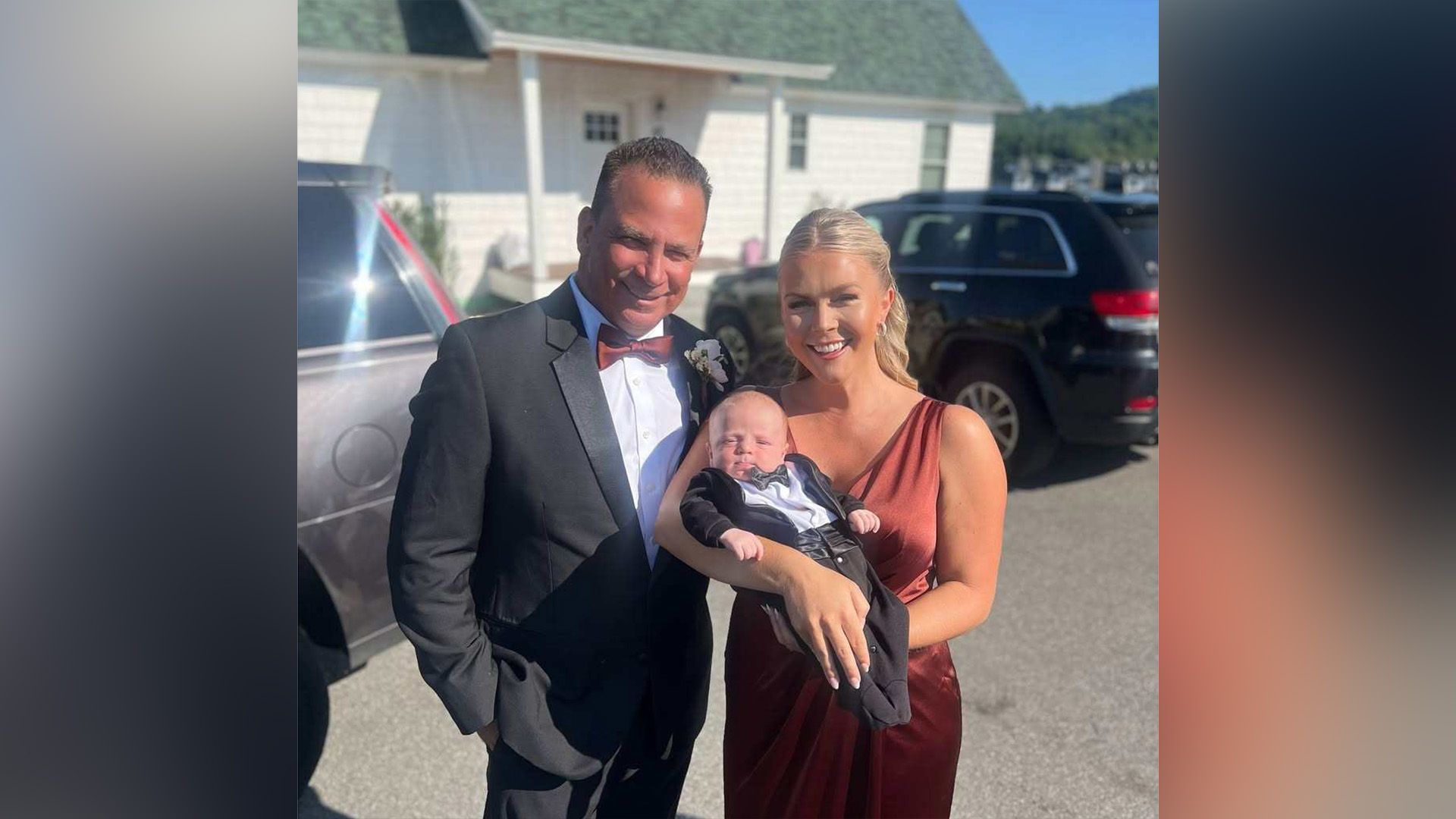 A man in a tailcoat and a woman in an elegant dress with a baby in her arms