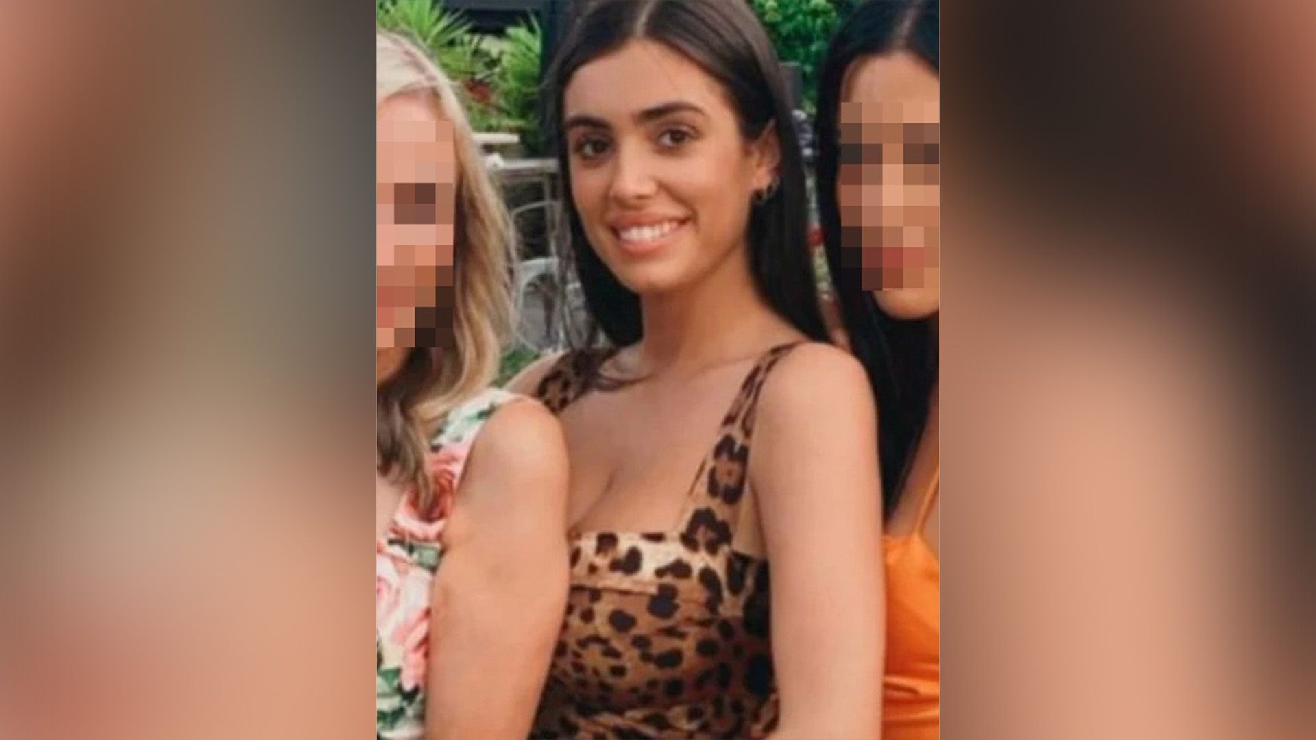 A smiling girl with long hair in a leopard print dress