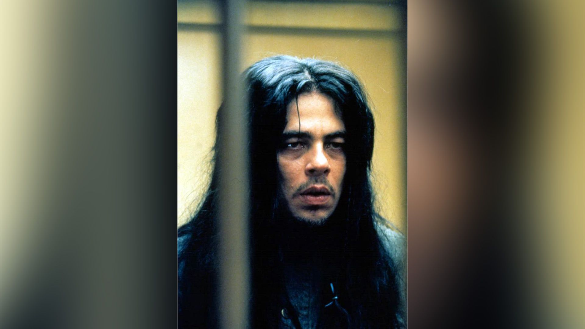 A man with a mustache and long black hair behind bars