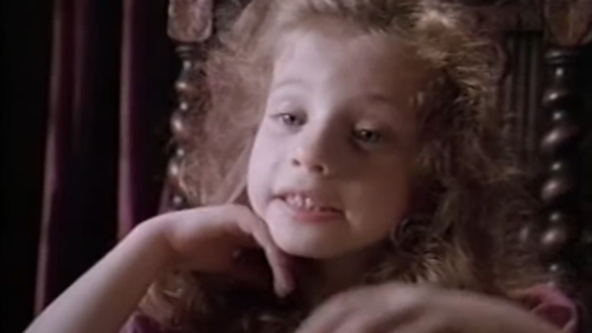 A little girl in a dress with curly hair