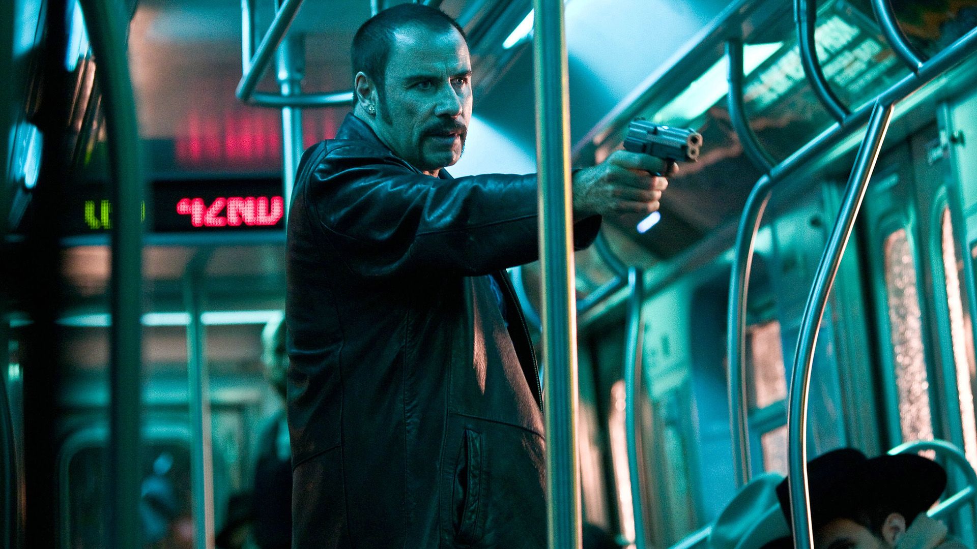 John Travolta with a gun in a subway car in a scene from 'The Taking of Pelham 123'