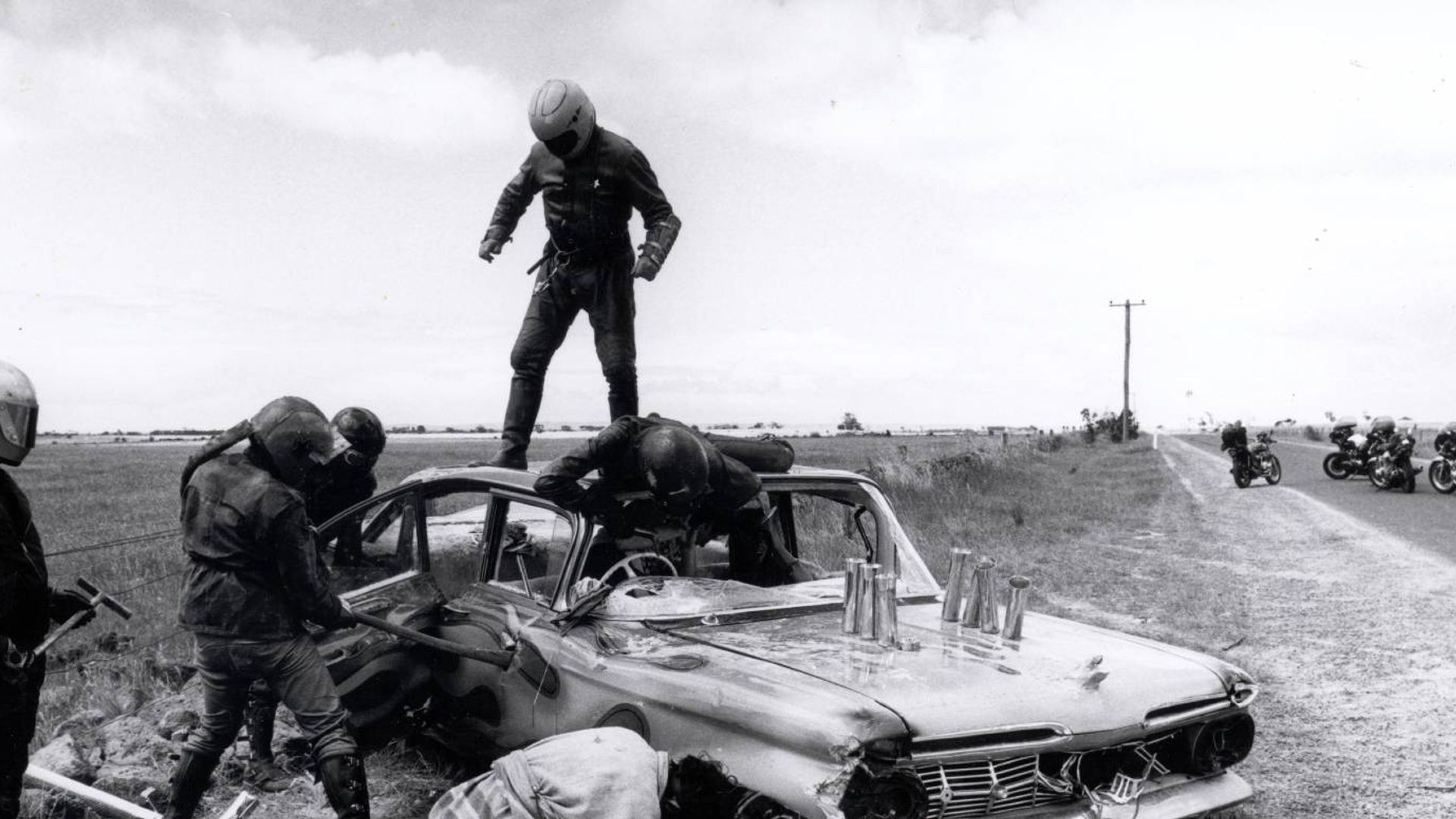 Shot from the movie "Mad Max": a gang of motorcyclists attacks a driver