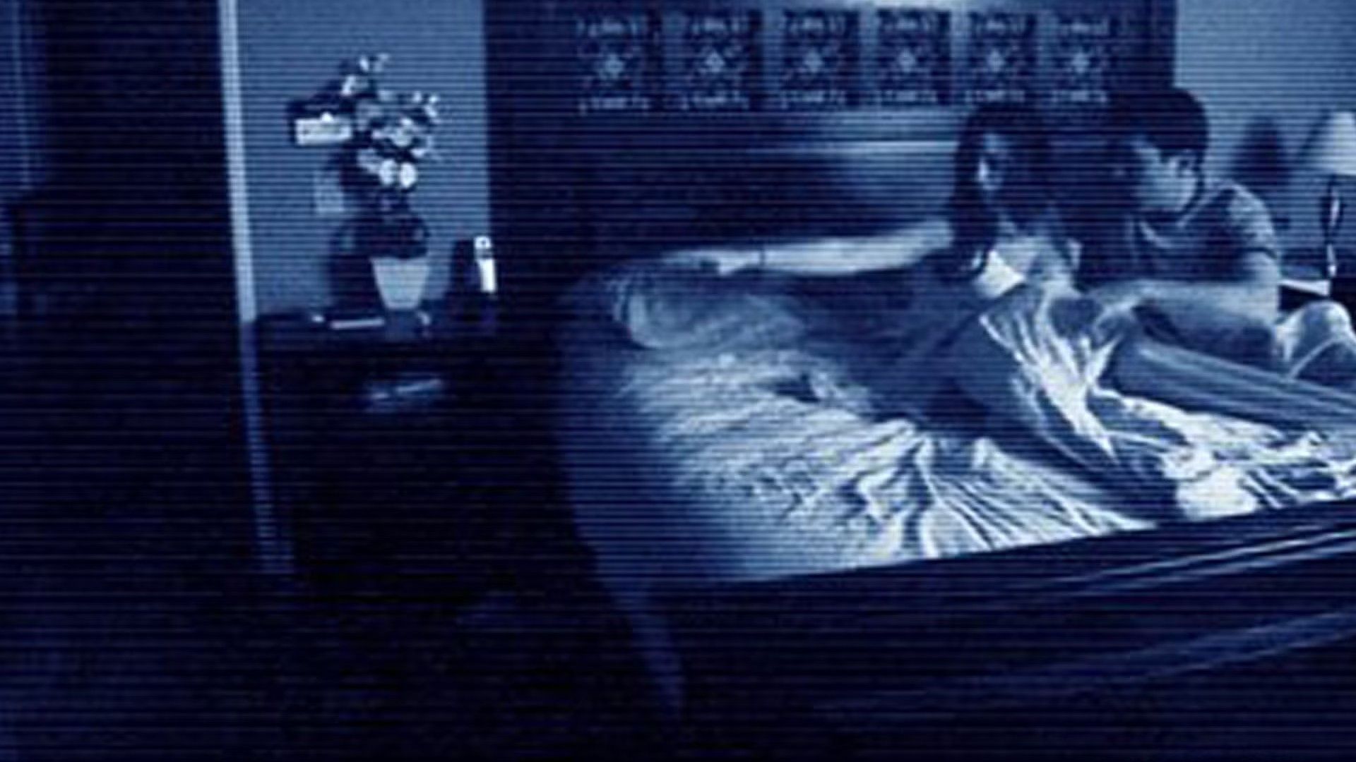 Shooting with a night camera, a man and a woman are sitting on the bed and pointing at something