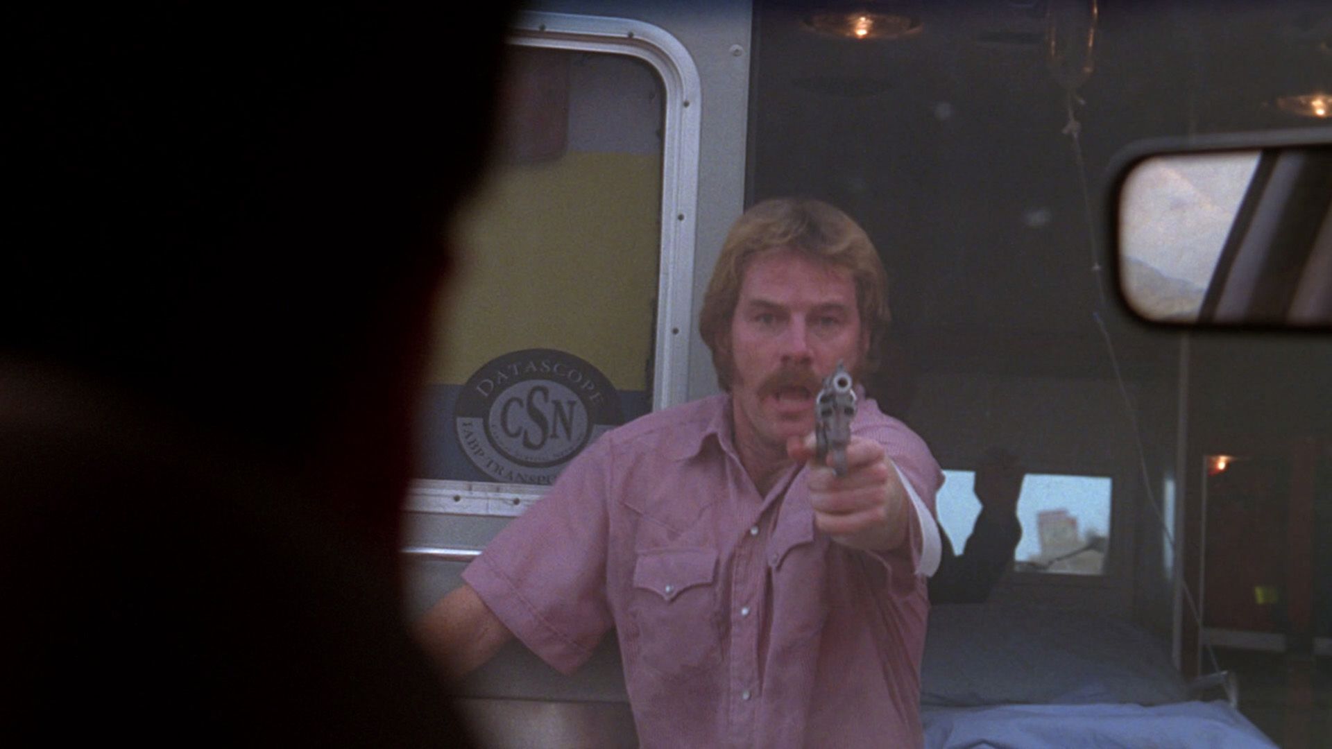 A frightened Bryan Cranston with a gun in his hand in a scene from "The X-Files"