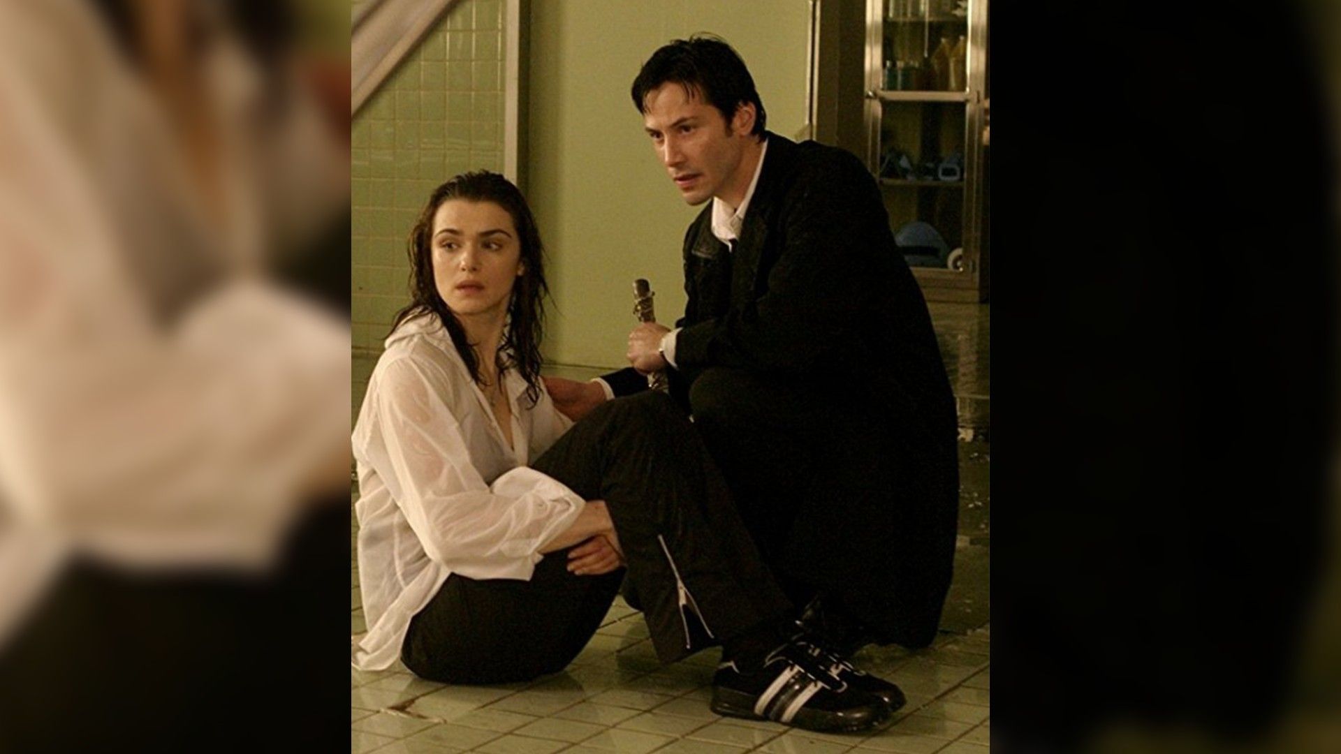 Rachel Weisz and Keanu Reeves sitting on the floor next to each other