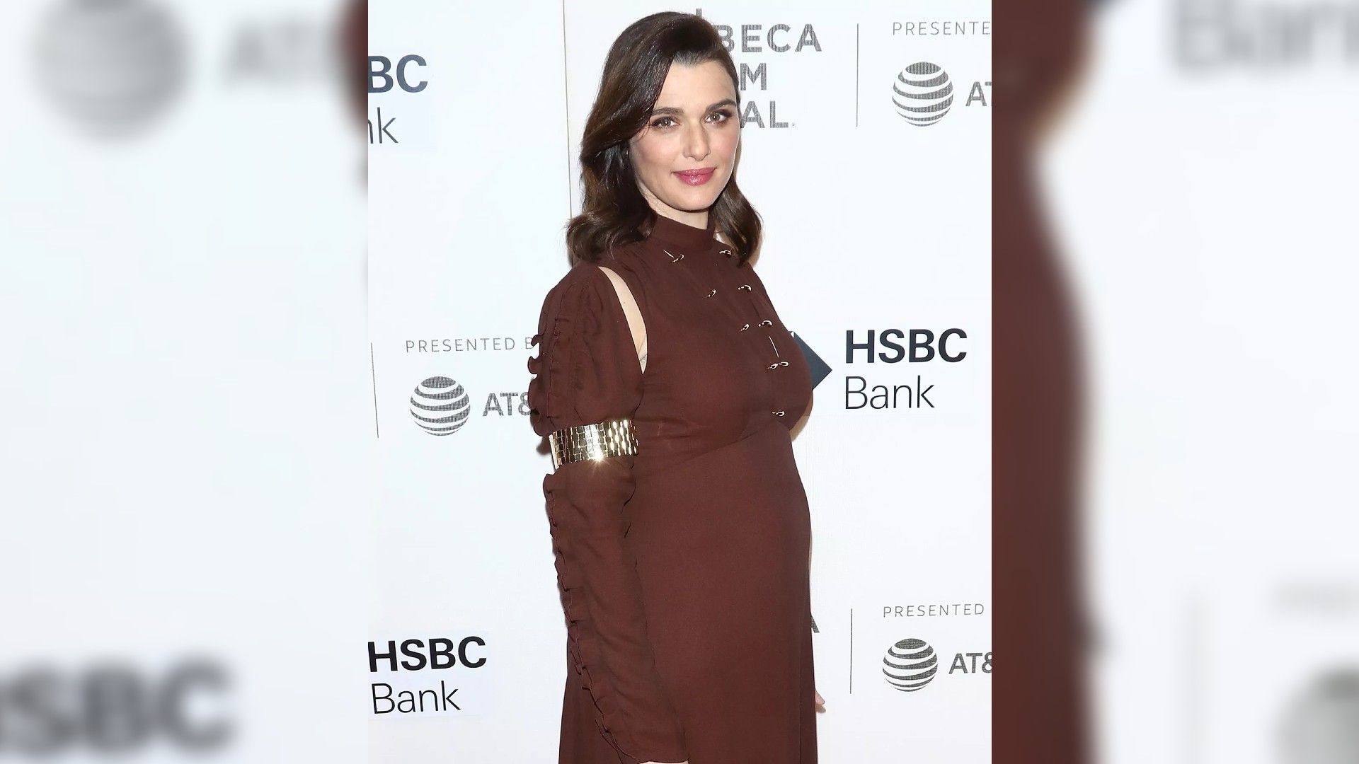 Rachel Weisz in a burgundy dress full-length, clearly showing she's expecting a child