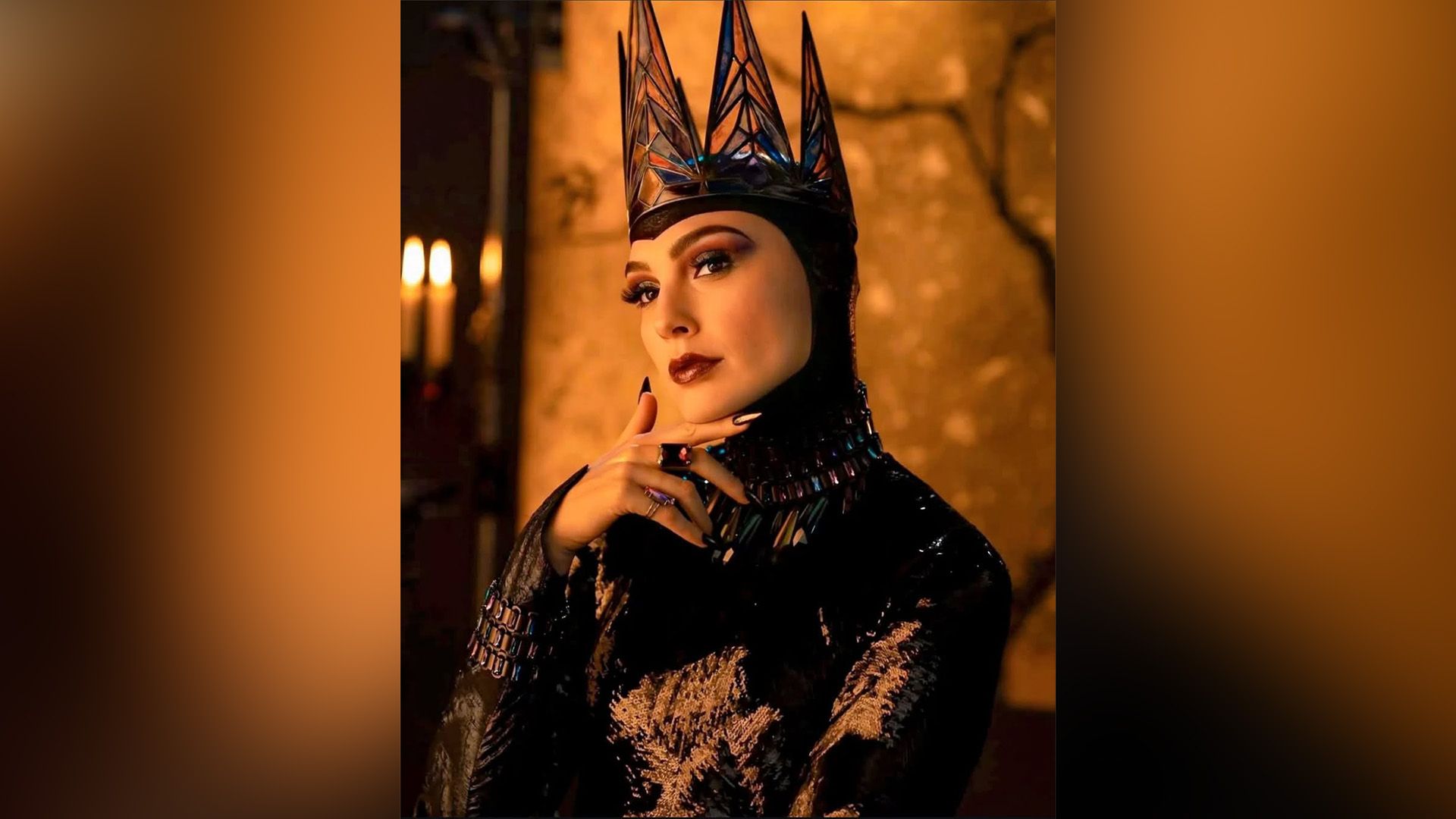 Gal Gadot as the Evil Queen in a black shiny outfit and a black crown