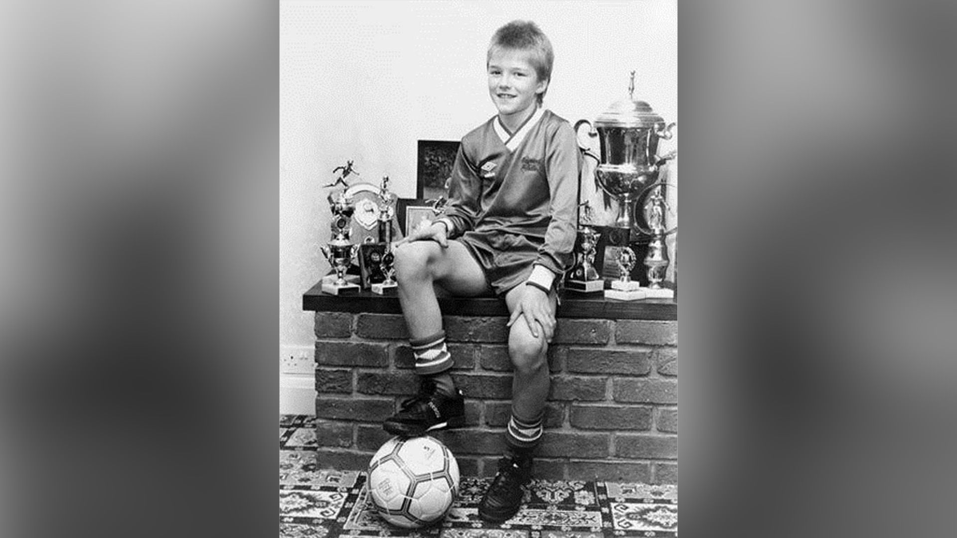 David Beckham as a child in a football kit and with a football