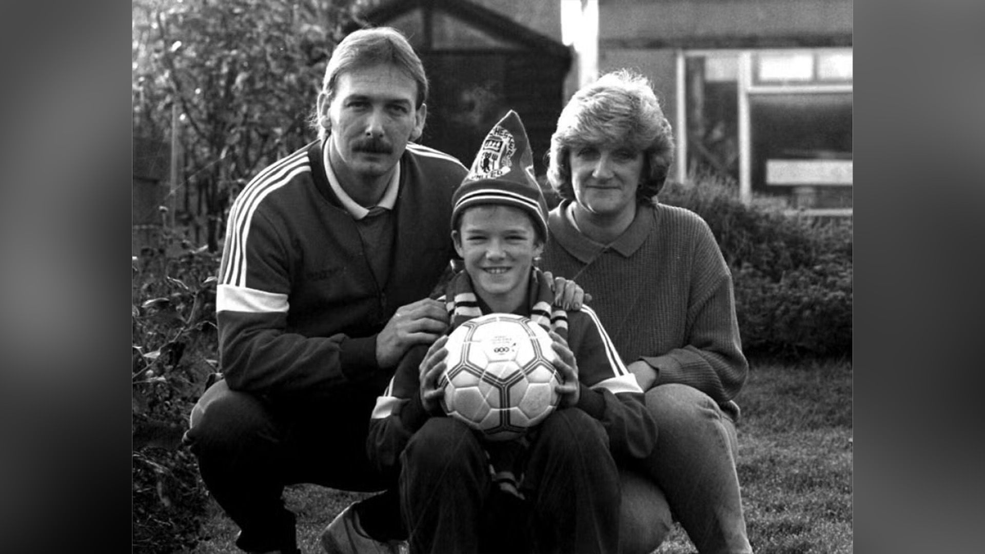 David Beckham as a child with his parents on the lawn in front of the house
