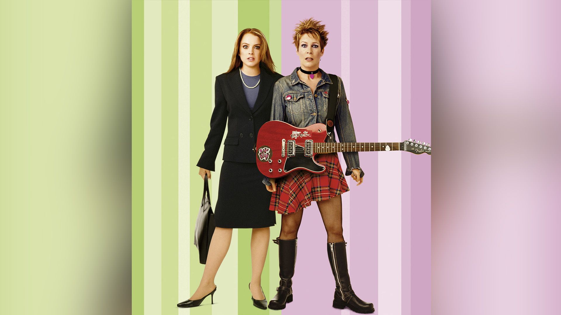 Lindsay Lohan in a strict suit and Jamie Lee Curtis in a denim jacket, plaid skirt, and with an electric guitar, both with surprised faces