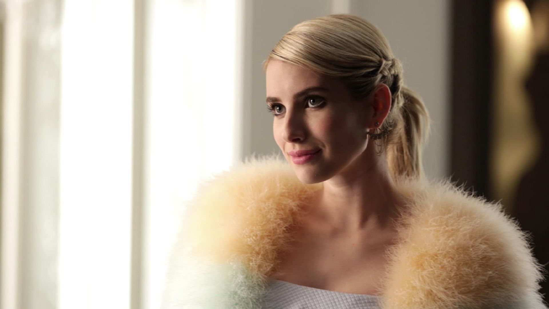 Emma Roberts in a fur cape looks sweetly to the left