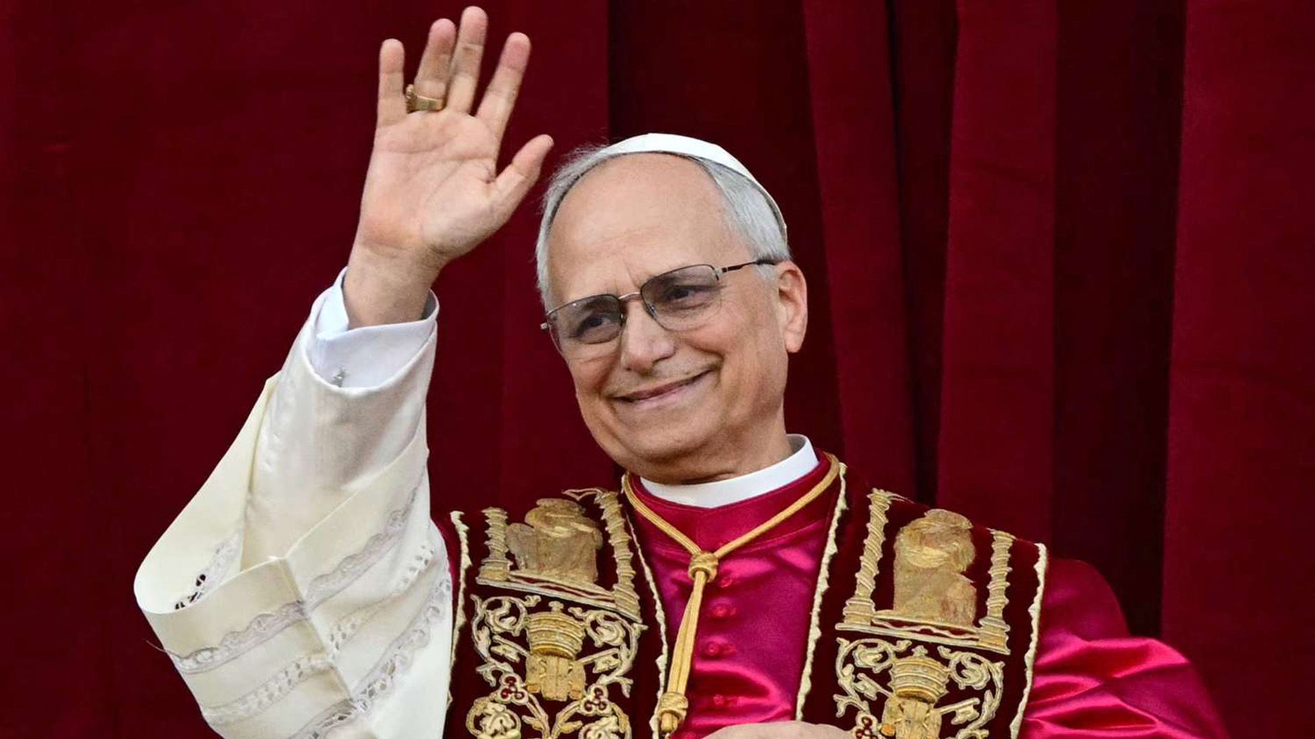 Pope Leo XIV (Robert Francis Prevost), dressed in red, waves his hand in greeting