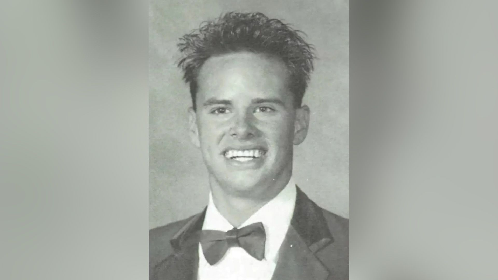 Young Walton Goggins, dressed in a bow tie, smiles broadly in a photo from the school album