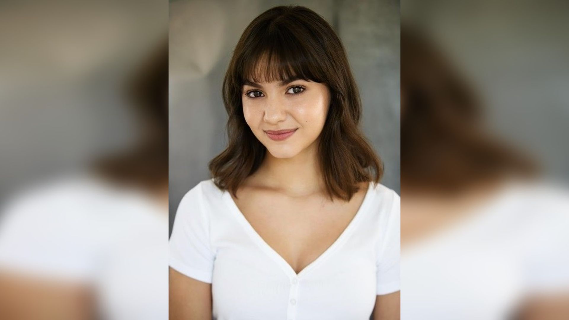 Samantha Lorraine in a white tank top looks into the frame
