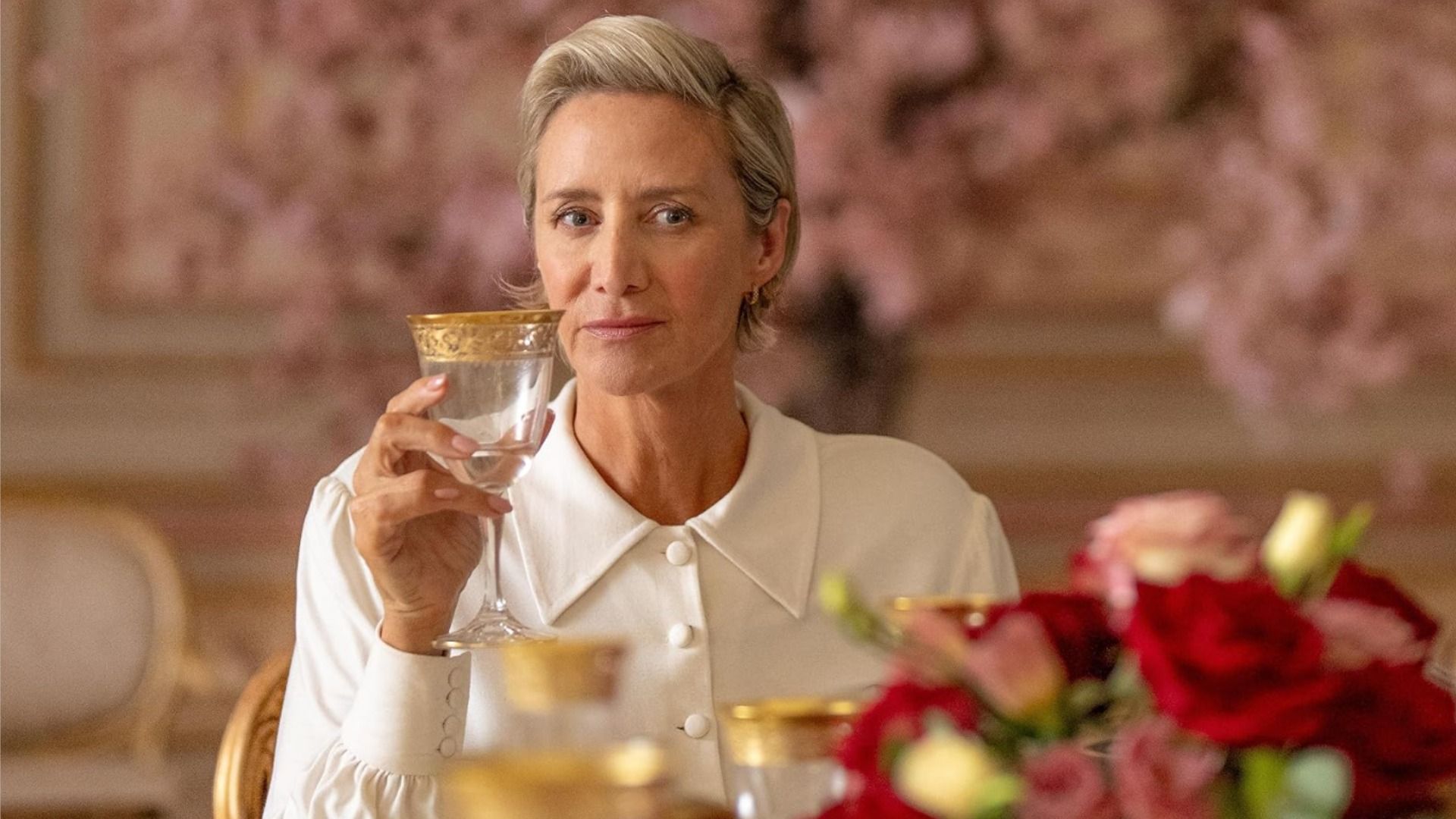 Actress Janet McTeer sitting in a white blouse with a glass in hand
