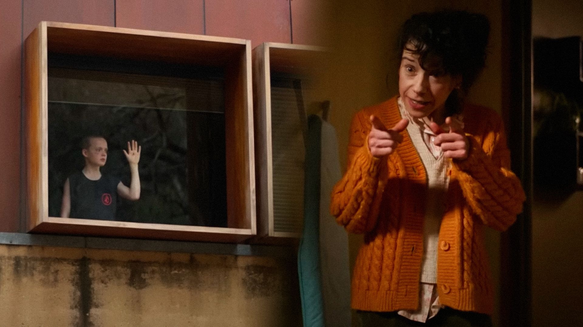 The boy placed his hand on the window glass and the woman holding out two index fingers in front of her