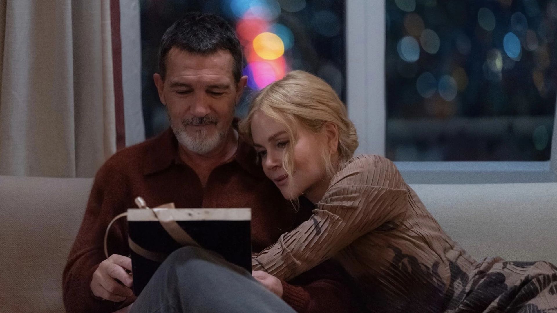 Antonio Banderas and Nicole Kidman sitting on a couch embracing
