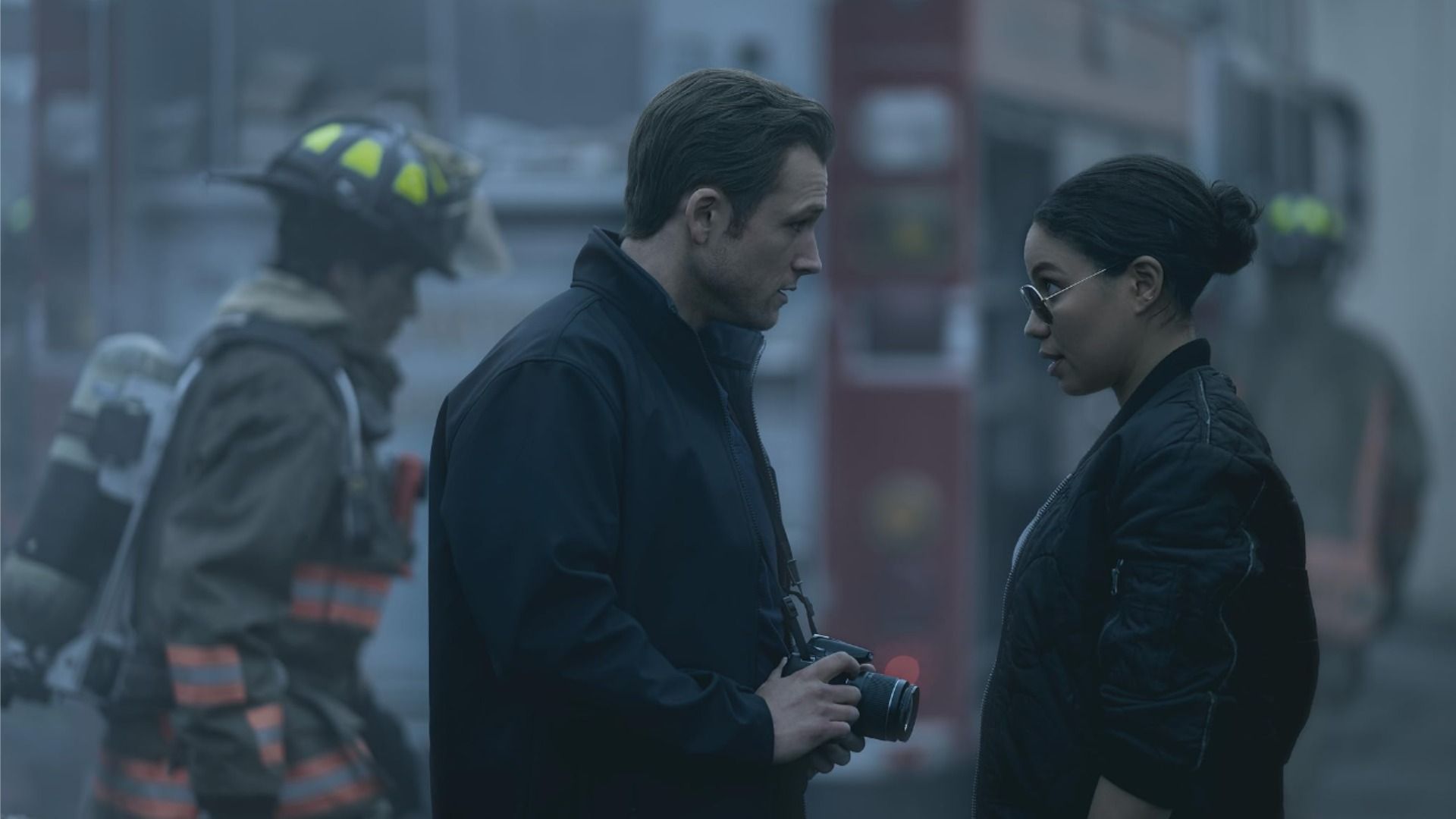 Actors Taron Egerton and Jurnee Smollett in black clothing look at each other