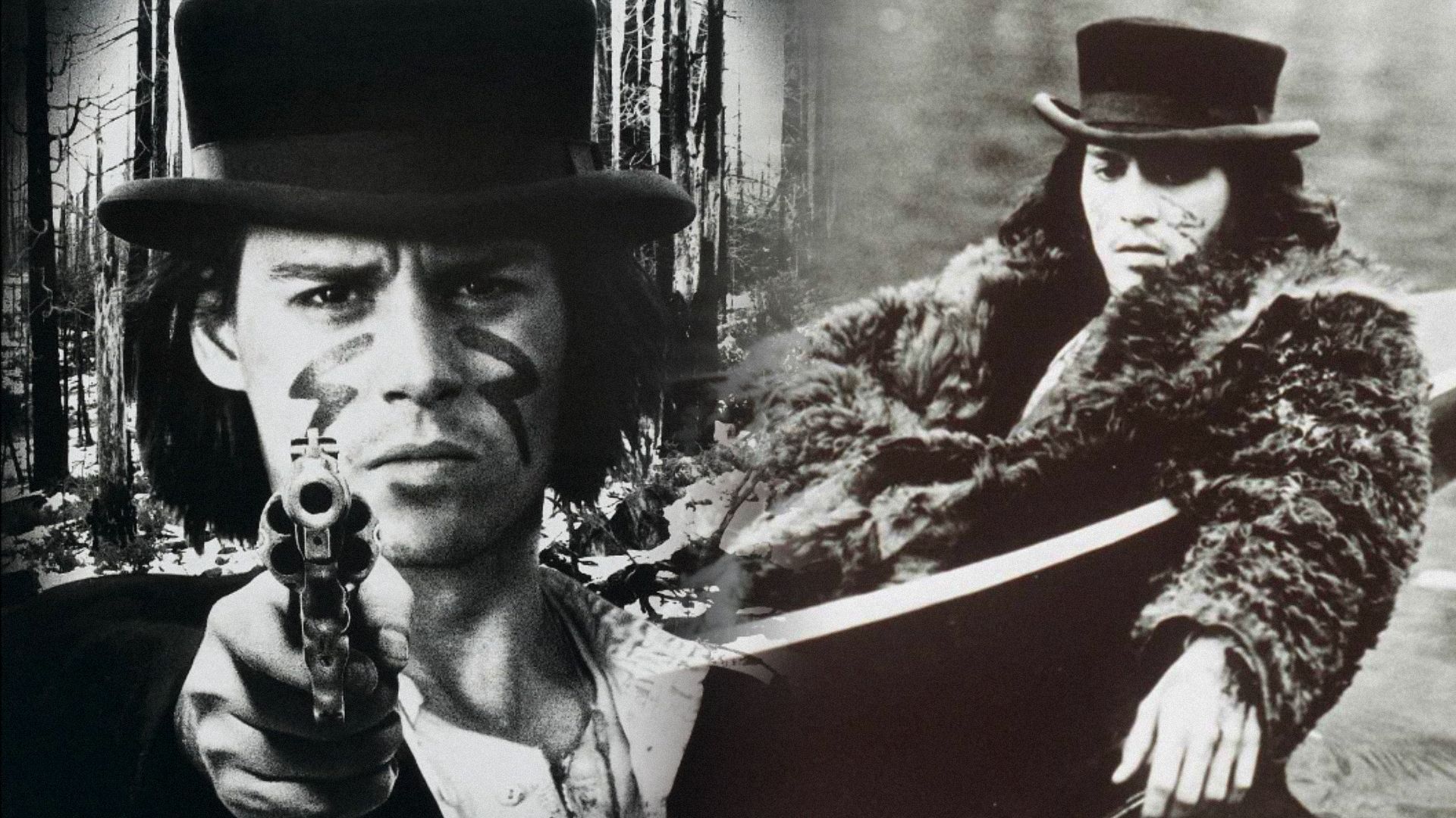 Actor Johnny Depp in a black hat holding a gun looks at the camera