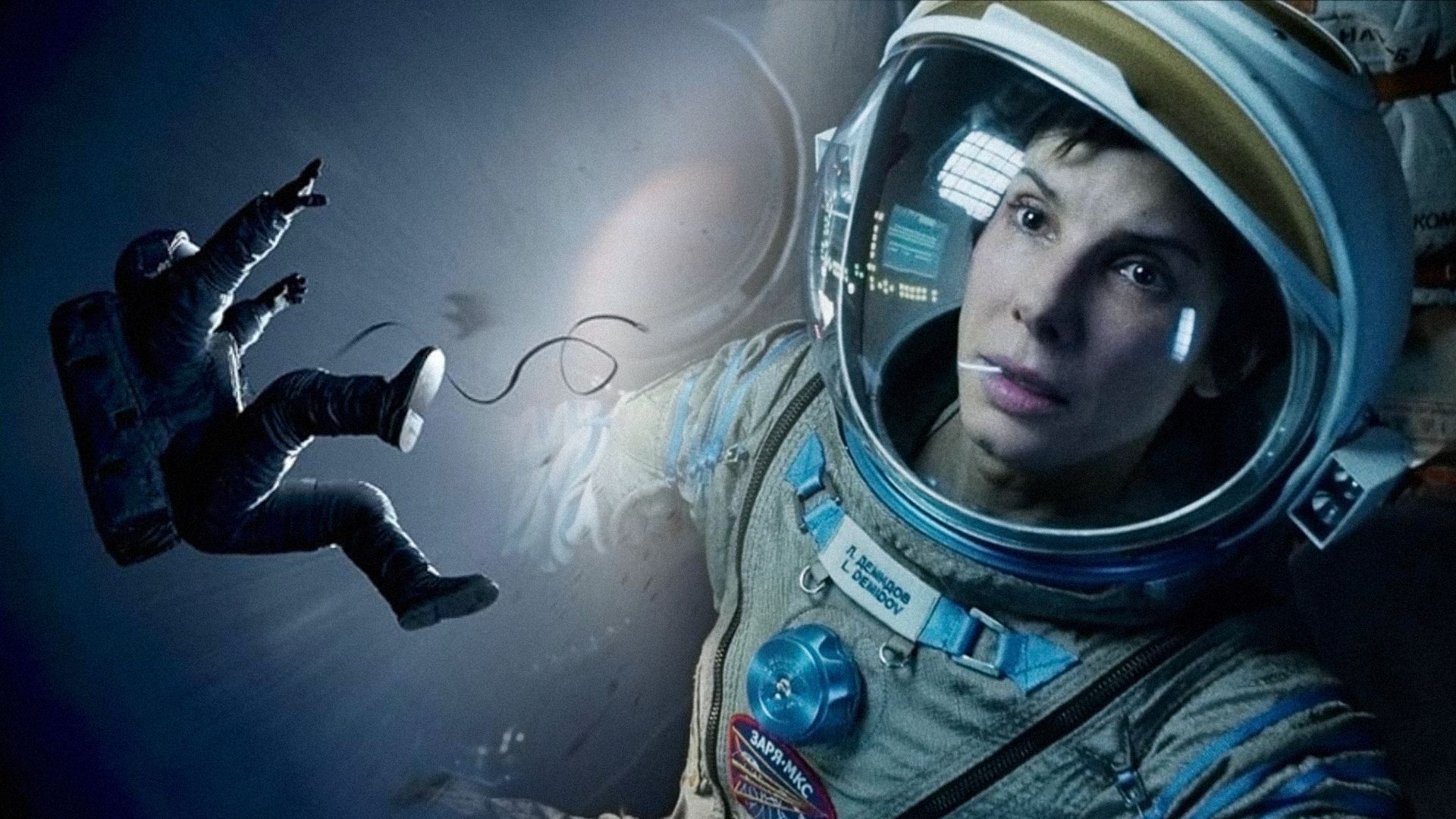 Actress Sandra Bullock in a spacesuit looking to the side with a serious expression on her face