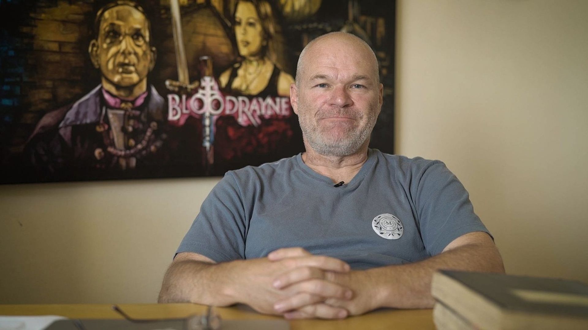 Director Uwe Boll against the backdrop of the BloodRayne movie poster